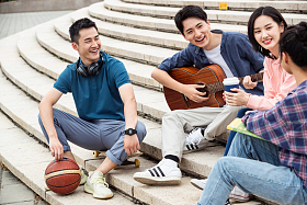 年轻的大学生坐在台阶上闲聊