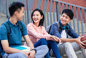 大学生坐在户外的楼梯上闲聊照片