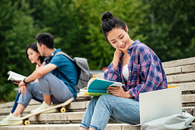 快乐的大学生坐在台阶上学习