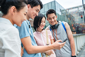 户外四个大学生一起看手机图片