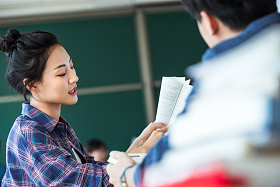 教室里回头讨论学习的大学生照片