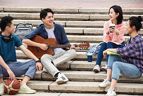 年轻的大学生坐在台阶上闲聊