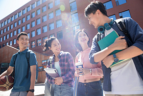 阳光下四个大学生在校园里边走边聊