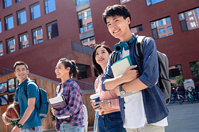 去上课的大学生情侣走在校园