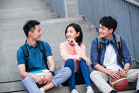 大学生坐在户外的楼梯上闲聊