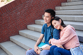 甜蜜的大学生情侣坐在楼梯上图片