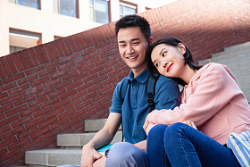 甜蜜的大学生情侣坐在楼梯上图片