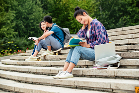 快乐的大学生坐在台阶上学习