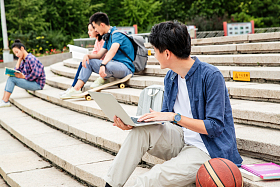 快乐的大学生坐在台阶上学习