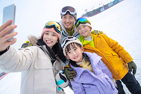 滑雪场上一家四口搂在一起自拍