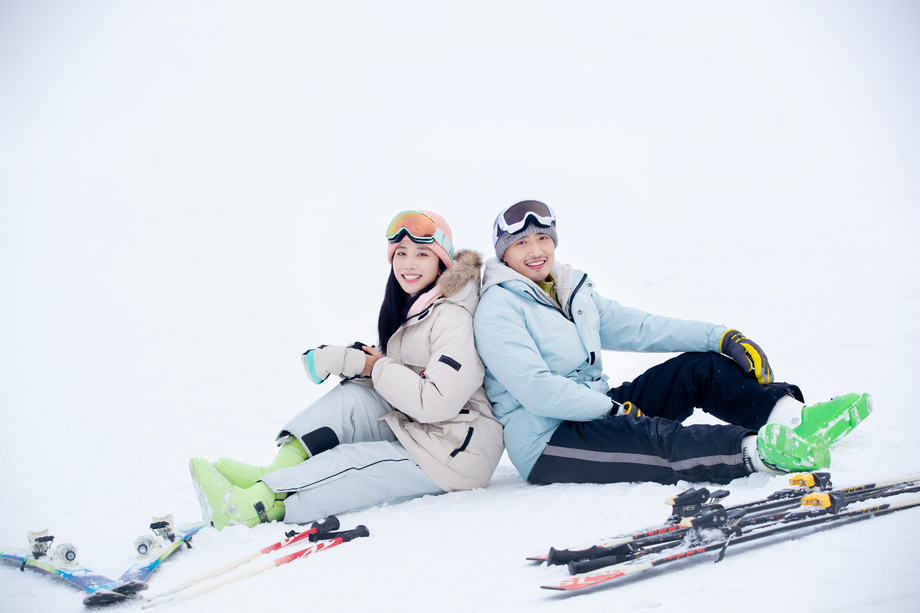 快乐的青年伴侣坐在雪地上图片