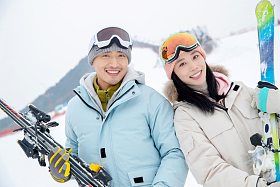 滑雪场快乐的青年伴侣拿着雪具