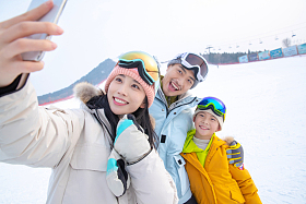 滑雪场上一家三口搂在一起自拍