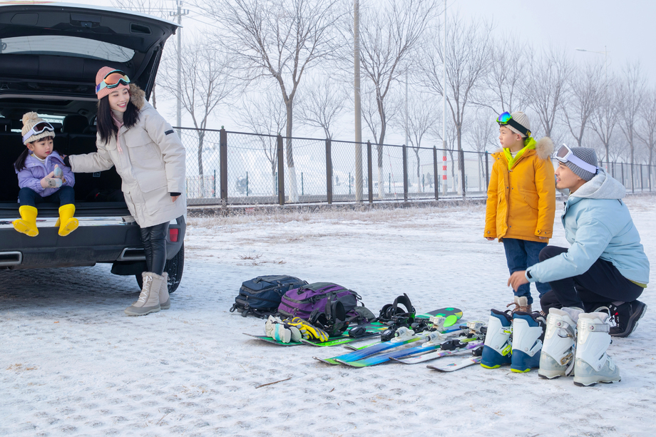 停车场内清点滑雪装备的一家四口