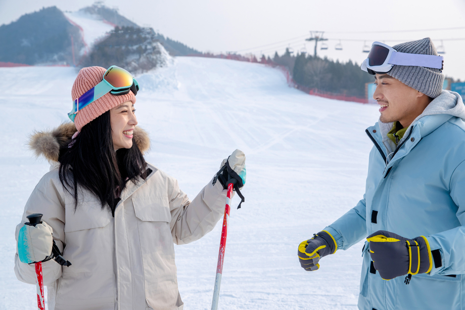 滑雪场上教女朋友滑雪的青年男人