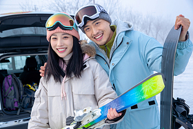 快乐的青年伴侣拿着滑雪板站z在一起