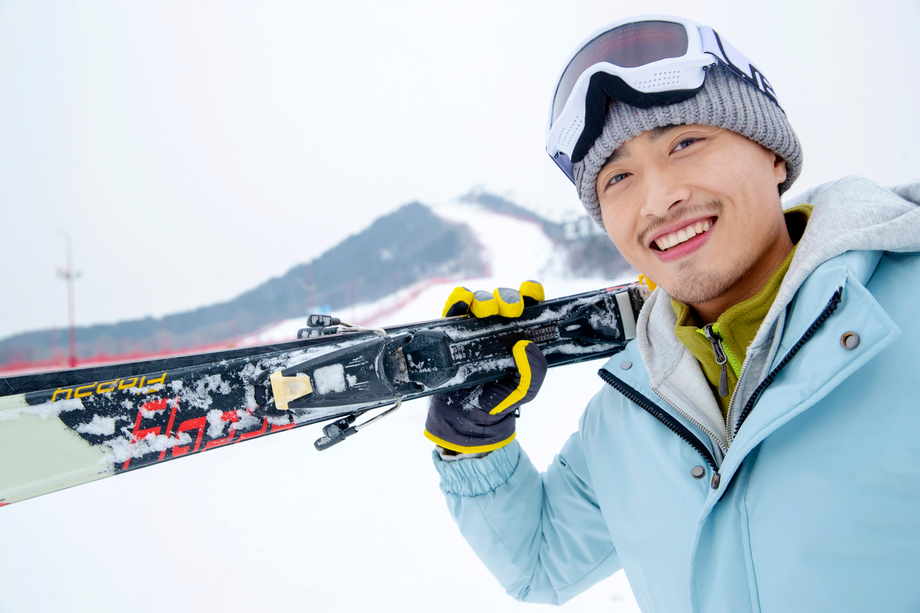 滑雪场上快乐的青年男人扛着滑雪板 滑雪场上快乐的青年男人扛着滑雪板