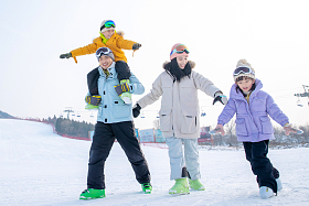 滑雪场上步行的一家四口图片
