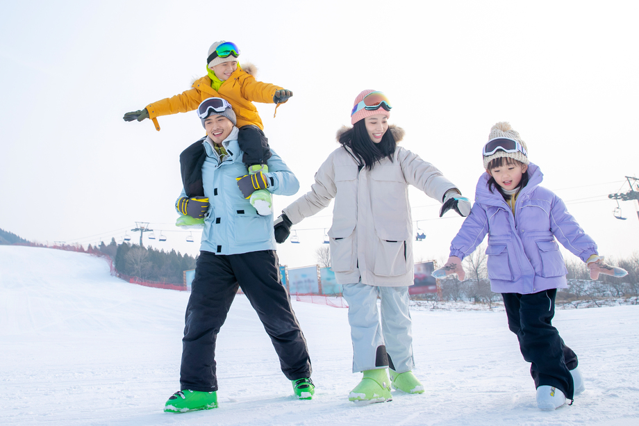 滑雪场上步行的一家四口图片