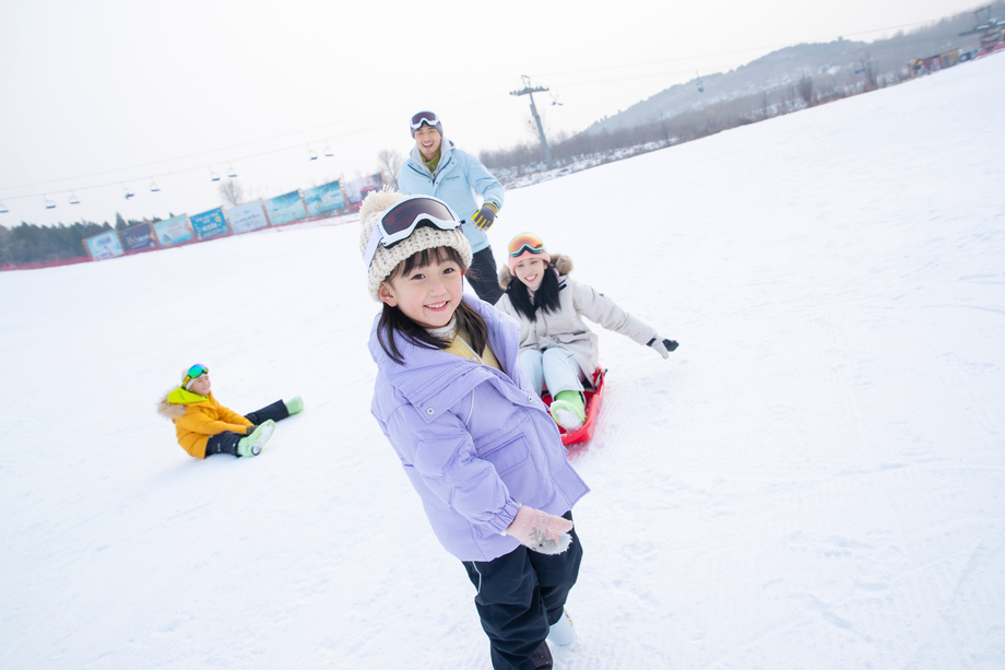 雪场上玩雪上滑板的一家四口图片 雪场上玩雪上滑板的一家四口图片