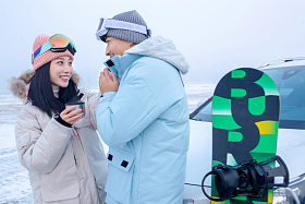 户外青年伴侣靠在汽车上拿着杯子交谈