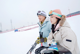 雪场上拿着滑雪板滑雪杖的快乐情侣