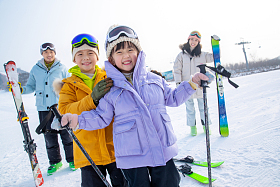 兴奋的年轻家庭来滑雪场滑雪图片