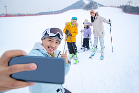 滑雪场上用手机自拍的一家四口