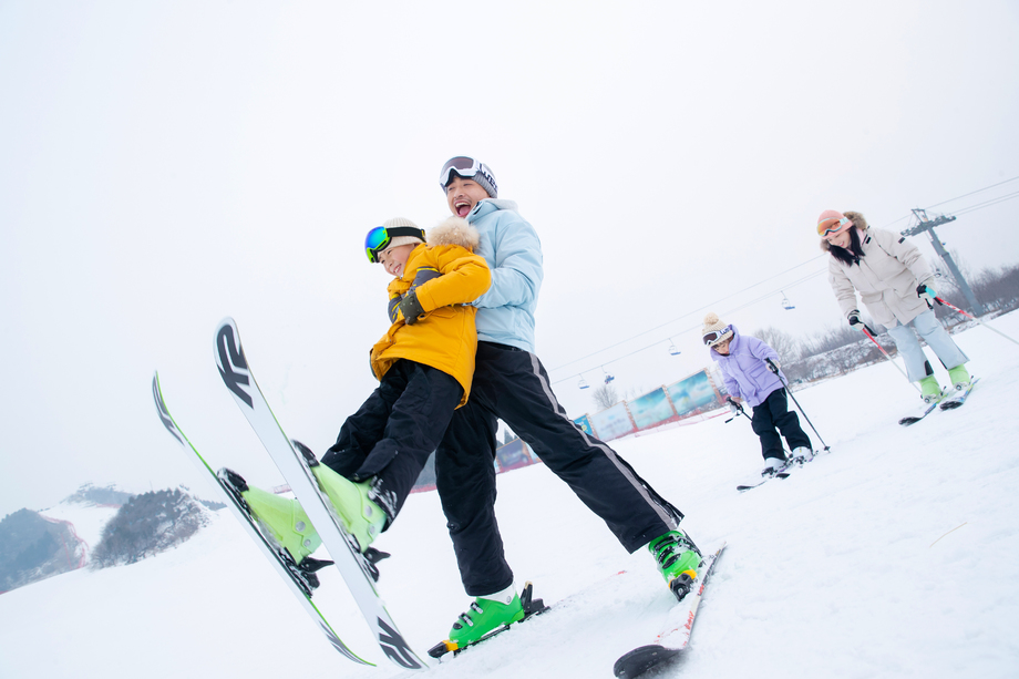滑雪场内边滑雪边嬉戏的一家四口 滑雪场内边滑雪边嬉戏的一家四口