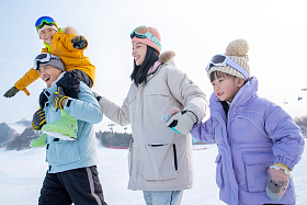滑雪场上步行的四口之家图片