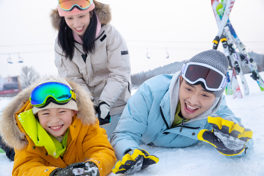 快乐的一家三口在雪地上玩雪