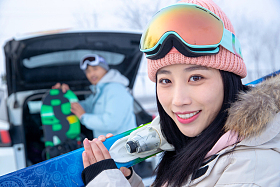 汽车后的年轻情侣扛着滑雪板图片