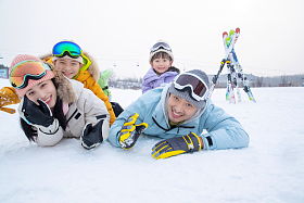 幸福快乐的一家四口趴在雪地上