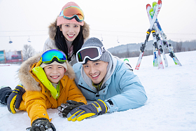 快乐幸福的一家三口趴在雪地上
