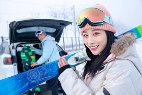 汽车后的年轻情侣扛着滑雪板图片