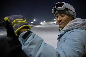 夜晚青年男人站在滑雪场内照片