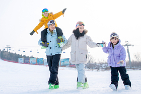 滑雪场上步行玩耍的一家四口