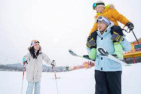 滑雪场内边滑雪边玩耍的三口之家