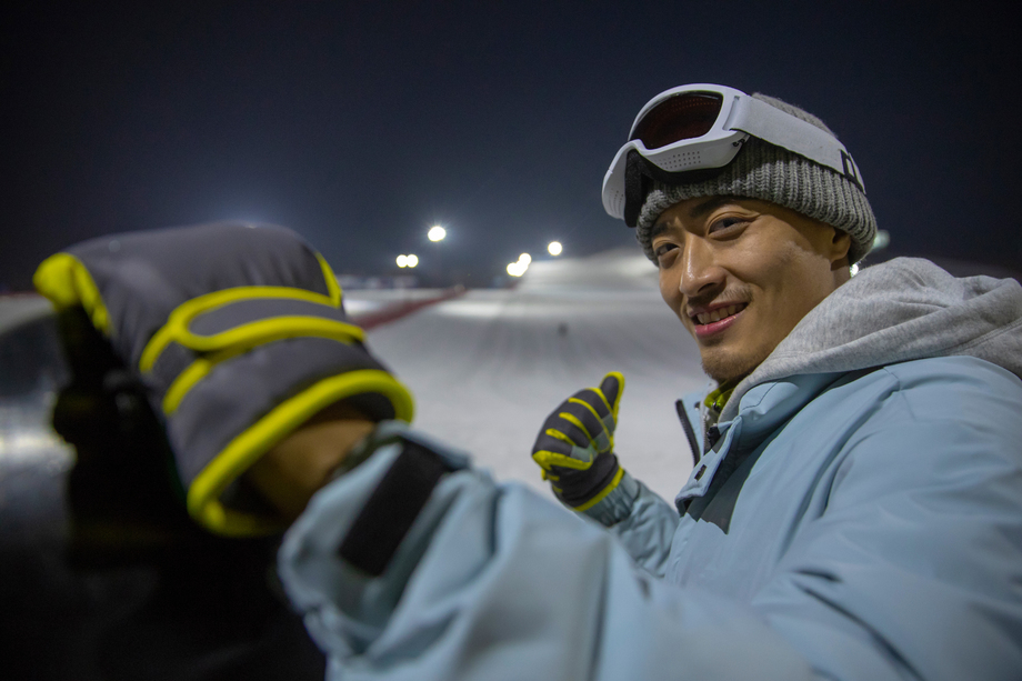 夜晚青年男人站在滑雪场内
