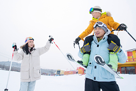 滑雪场内边滑雪边玩耍的三口之家