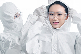 年轻女医生互相协助穿防护服图片