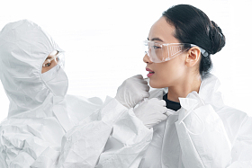 年轻女医生互相协助穿防护服