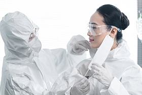 年轻女医生互相协助穿防护服