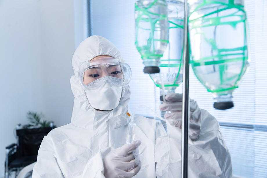 青年女医生调试生理盐水 青年女医生调试生理盐水