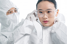 年轻女医生互相协助穿防护服