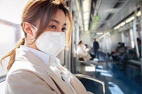 年轻女人戴口罩坐地
