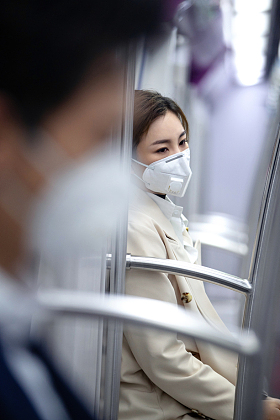 年轻女人戴口罩坐地
