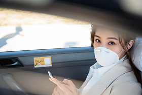 年轻女人戴口罩乘坐汽车图片