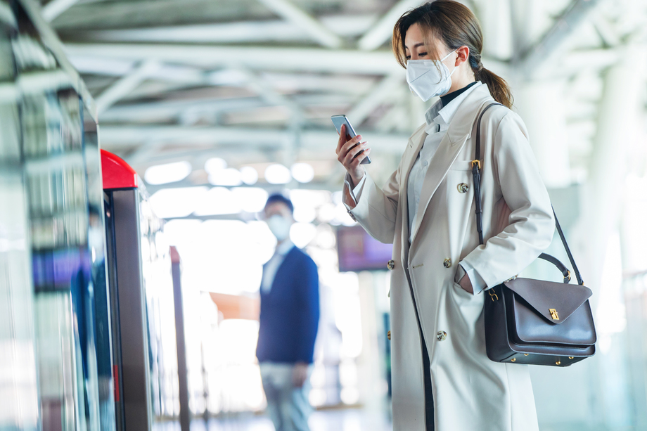 戴口罩的年轻女人站在地铁站台上 戴口罩的年轻女人站在地铁站台上