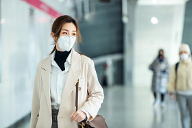 戴口罩的年轻女人走在地铁站